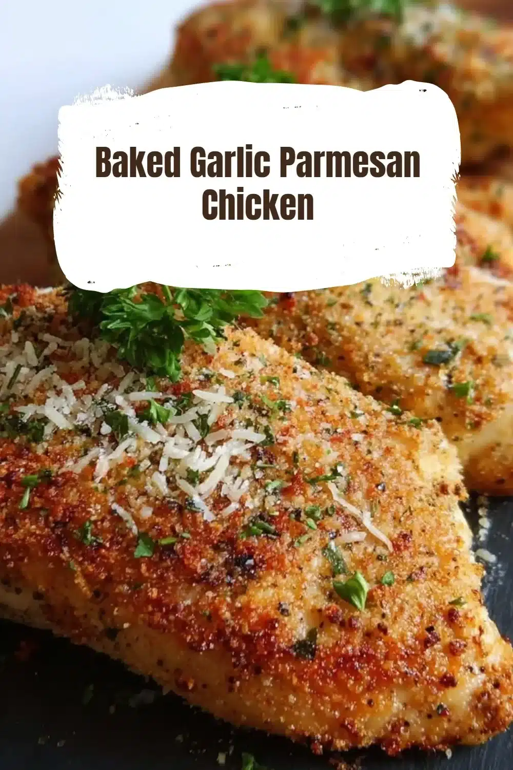 Baked Garlic Parmesan Chicken 1 Deliciously baked garlic parmesan chicken served on a plate with herbs.