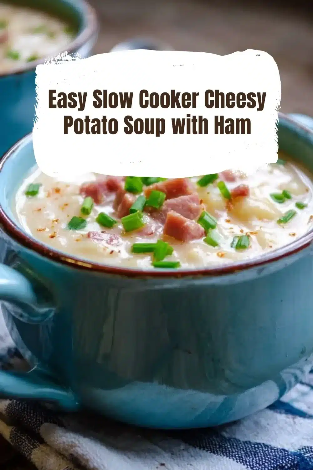 Bowl of easy slow cooker cheesy potato soup with ham, garnished with herbs.