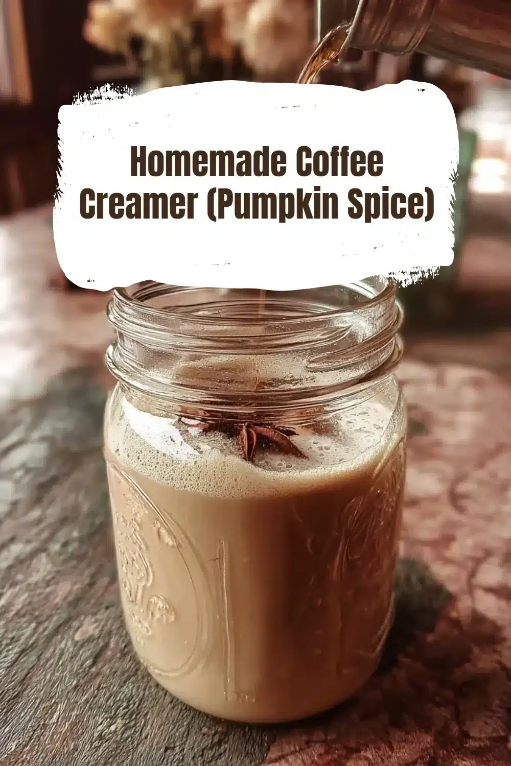 Homemade pumpkin spice coffee creamer in a glass container with spices around it.