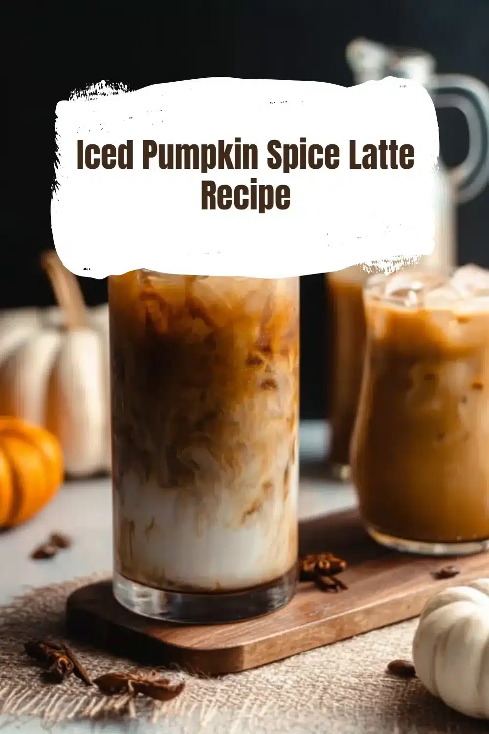Refreshing iced pumpkin spice latte in a glass with fall spices on the side