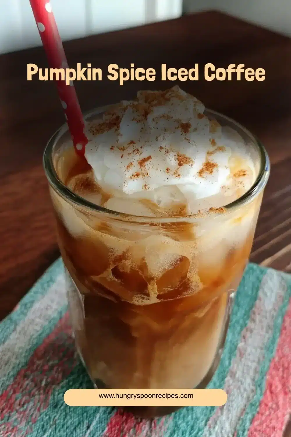A delicious cup of pumpkin spice iced coffee topped with whipped cream and cinnamon.