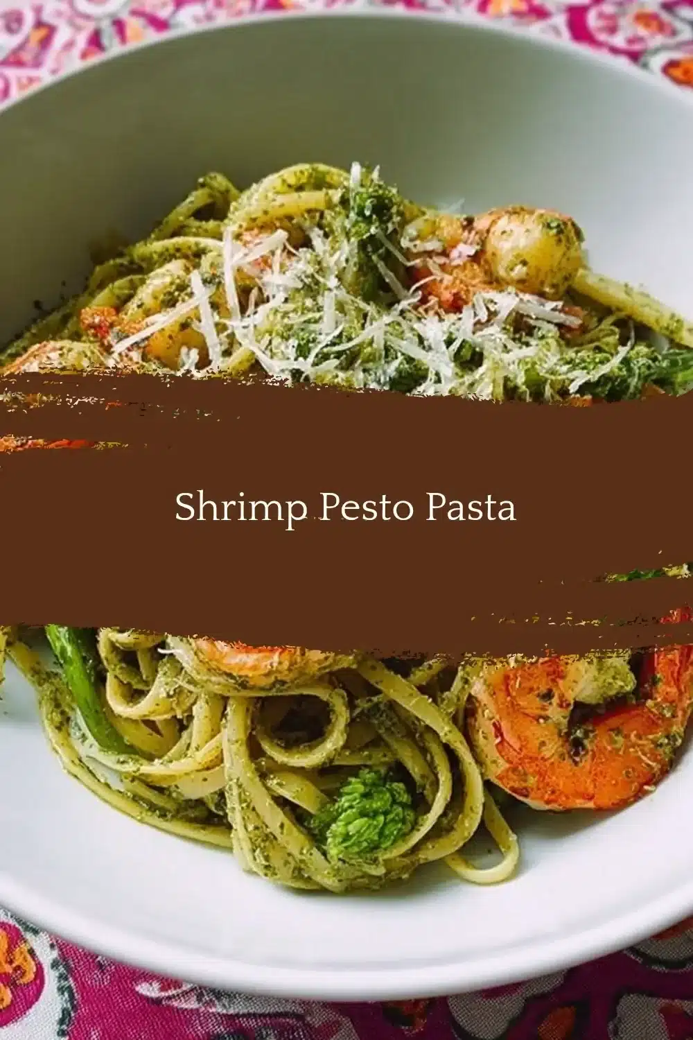 Delicious Shrimp Pesto Pasta served in a bowl with fresh basil and parmesan.