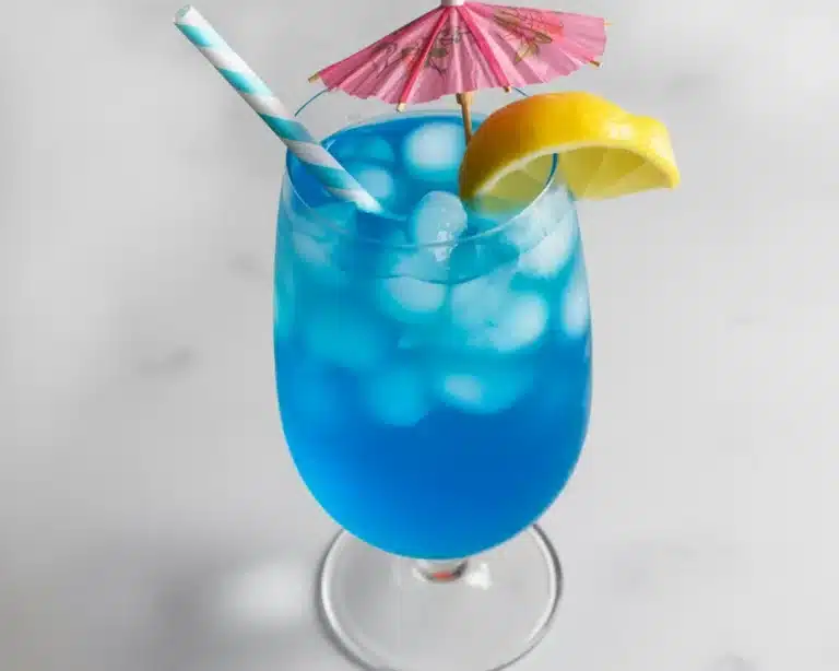 Blue Lagoon Mocktail made with blue curaçao syrup and lemonade, garnished with citrus.