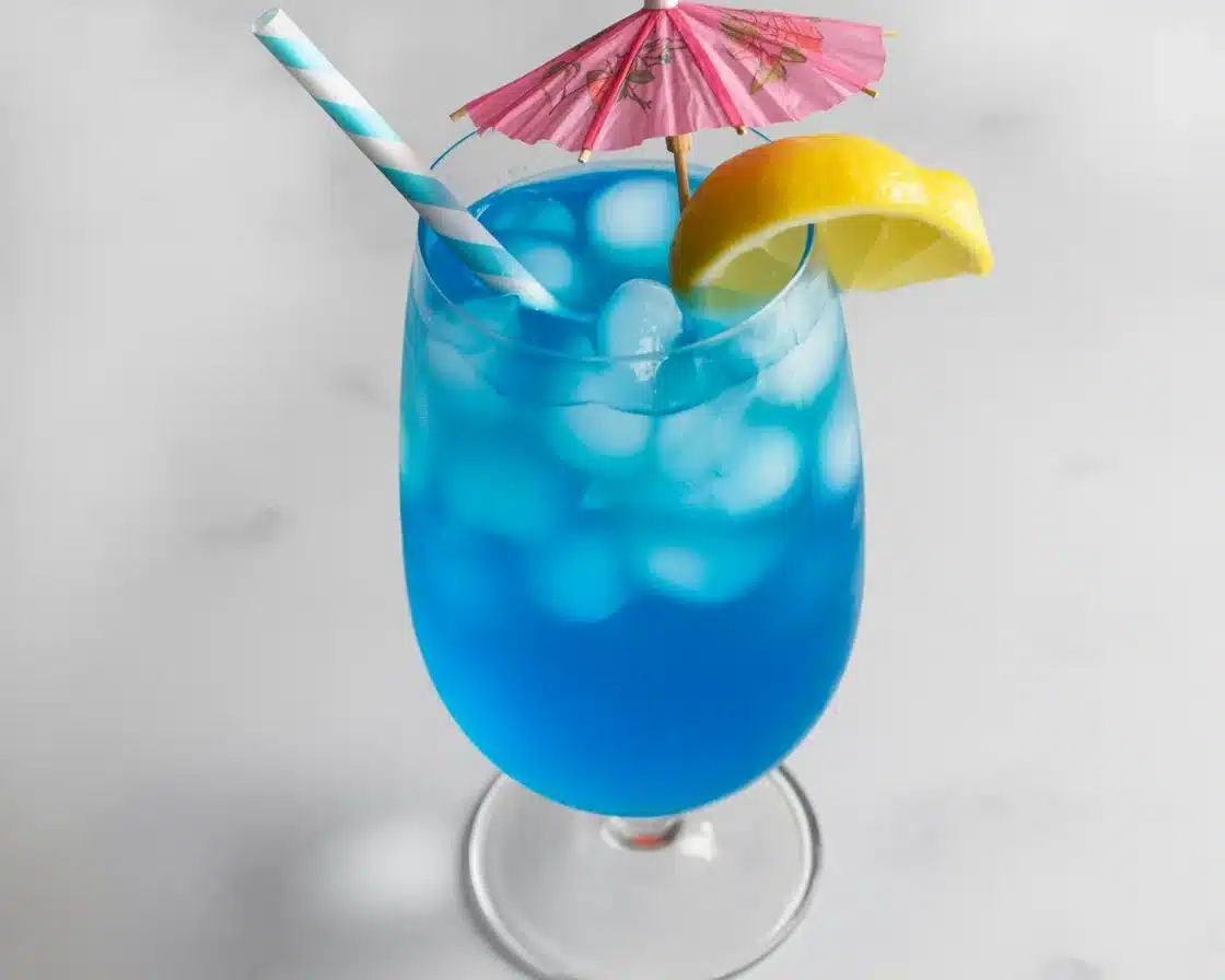 Blue Lagoon Mocktail made with blue curaçao syrup and lemonade, garnished with citrus.