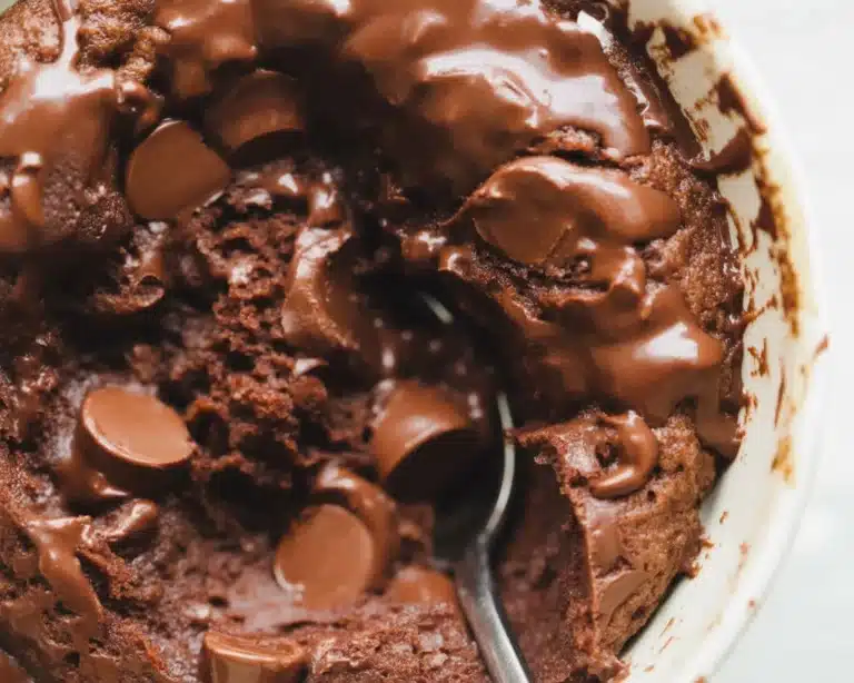 Delicious low carb keto mug cake topped with chocolate sprinkles in a mug.